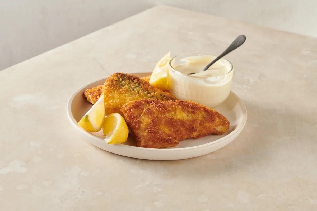 Filets de poisson panés de la catégorie . Méthode de préparation rôtir. Le plat terminé est joliment présenté et photographié en vue aérienne (photographie alimentaire). Suggestion de présentation, recette originale de Croqu'menus, tirée du livre de cuisine le plus connu de Suisse