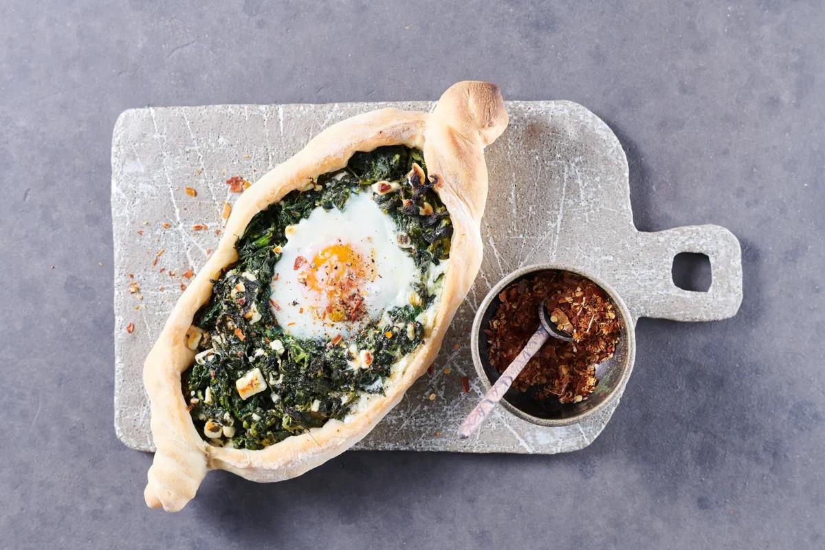Pide aux épinards et au fromage aus der Kategorie Gebäck salzig. Das fertige Gericht schön angerichtet und fotografiert aus Vogelperspektive (Food Fotografie). Serviervorschlag, Original Tiptopf Rezept, aus dem bekanntesten Kochbuch der Schweiz