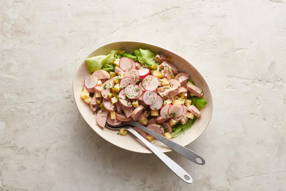Salade de cervelas au fromage aus der Kategorie Salate. Das fertige Gericht schön angerichtet und fotografiert aus Vogelperspektive (Food Fotografie). Serviervorschlag, Original Tiptopf Rezept, aus dem bekanntesten Kochbuch der Schweiz