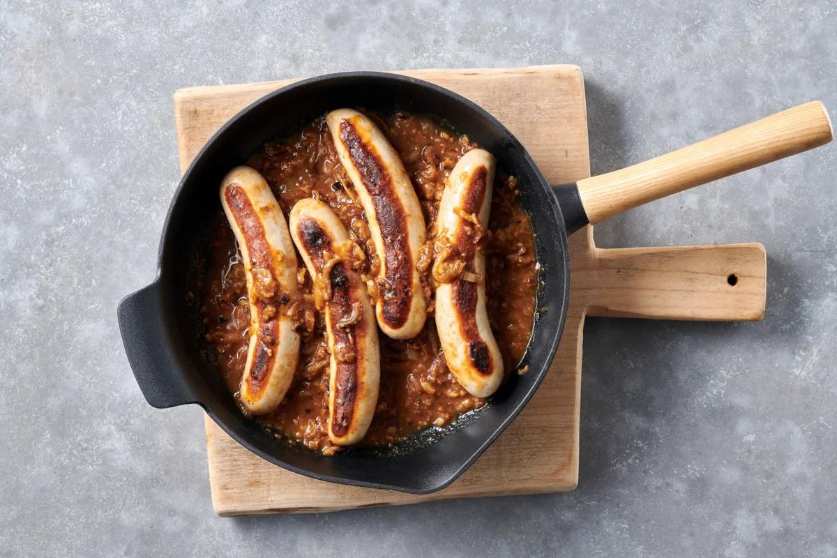 Saucisses avec sauce aus der Kategorie Fleisch &amp; Fisch. Das fertige Gericht schön angerichtet und fotografiert aus Vogelperspektive (Food Fotografie). Serviervorschlag, Original Tiptopf Rezept, aus dem bekanntesten Kochbuch der Schweiz