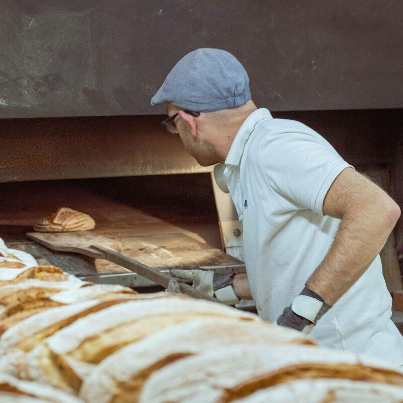 Mann in der Backstube beim Brotbacken