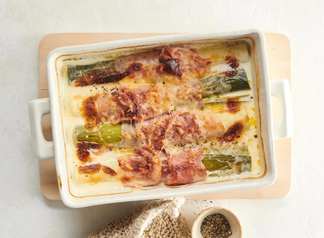 Poireau au jambon de la catégorie . Méthode de préparation cuire. Le plat terminé est joliment présenté et photographié en vue aérienne (photographie alimentaire). Suggestion de présentation, recette originale de Croqu'menus, tirée du livre de cuisine le plus connu de Suisse