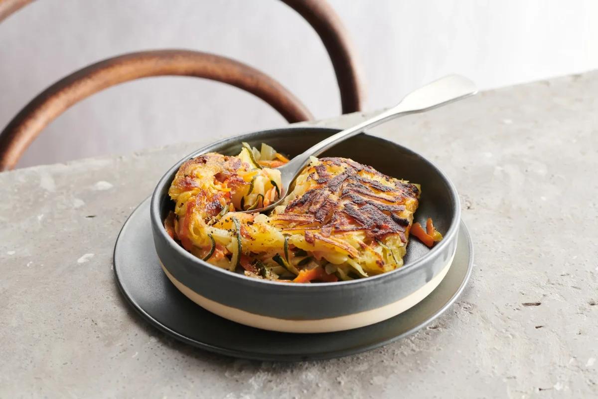 Rösti aux légumes aus der Kategorie Kartoffeln & Süsskartoffeln. Das fertige Gericht schön angerichtet und fotografiert aus Vogelperspektive (Food Fotografie). Serviervorschlag, Original Tiptopf Rezept, aus dem bekanntesten Kochbuch der Schweiz